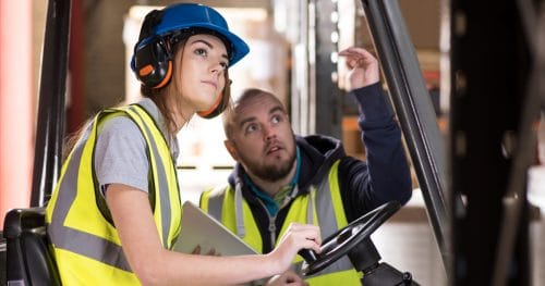 Woman on a Forklift being trained by a supervisor
