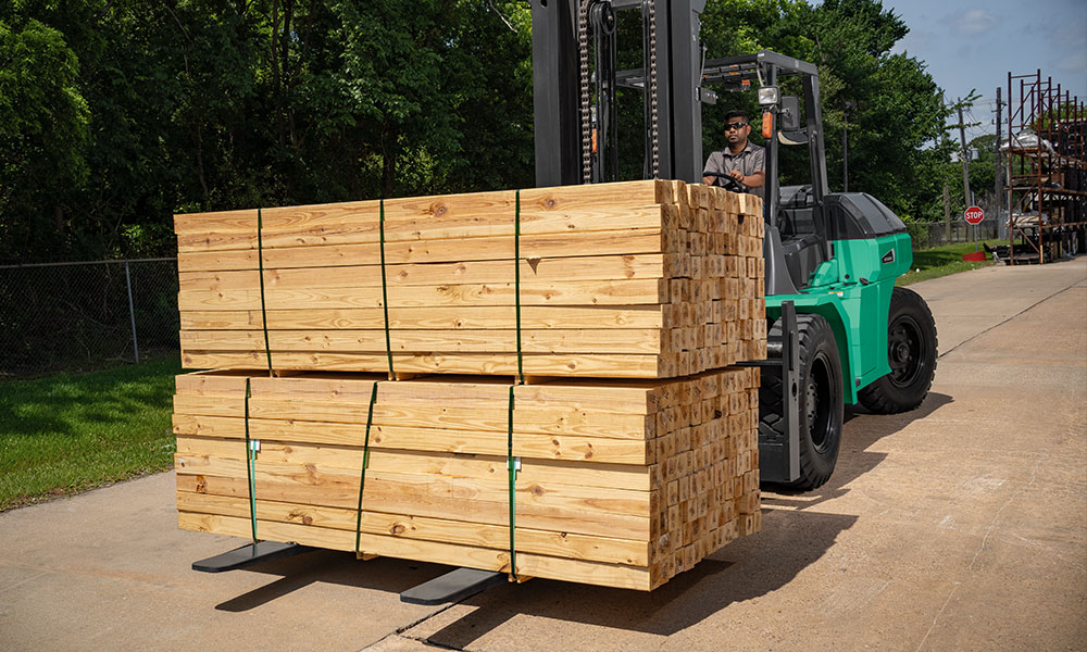 Mitsubishi pneumatic tire forklift carrying a load of lumber