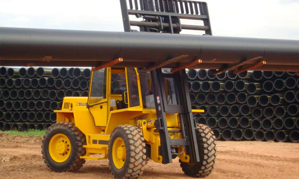 Sellick rough terrain forklift moving a long pipe