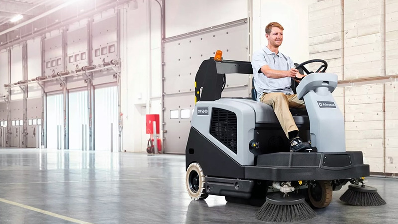 Man using an Advance floor cleaning sweeper scrubber